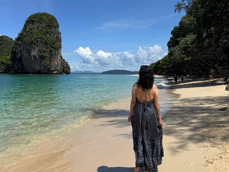 Woman in long dress walking on the beach