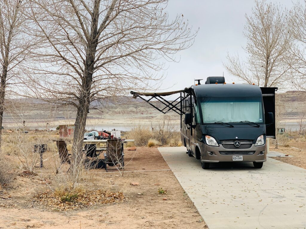 RVshare rental RV with a bumpout on a campsite with a picnic table.