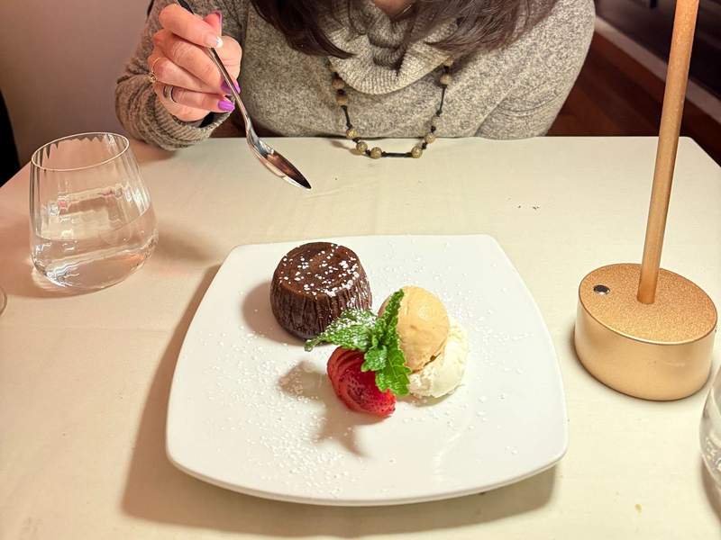 Gluten free chocolate lava cake on a white square plate.