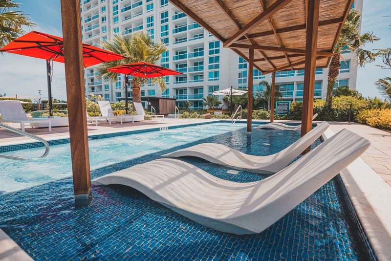 Rooftop infinity pool with shaded sun beds at Radisson Blu Aruba.