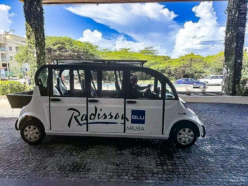 Blue and white beach shuttle van at Radisson Blu Aruba.