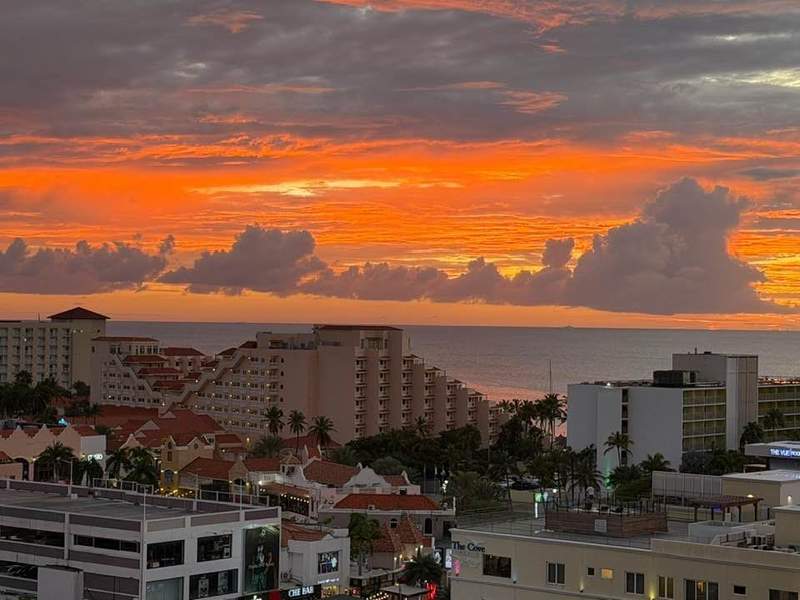 Orange sunset over ocean viewed from balcony in Aruba.