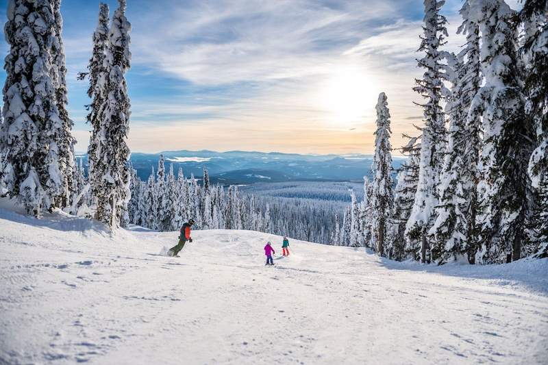 Family skiing down the slopes at Big White Ski Resort in British Columbia.