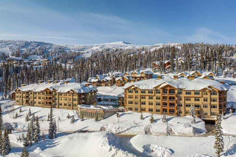 Aerial view of the snow-covered Sundance Resort with the mountains in the background at Big White Ski Resort.