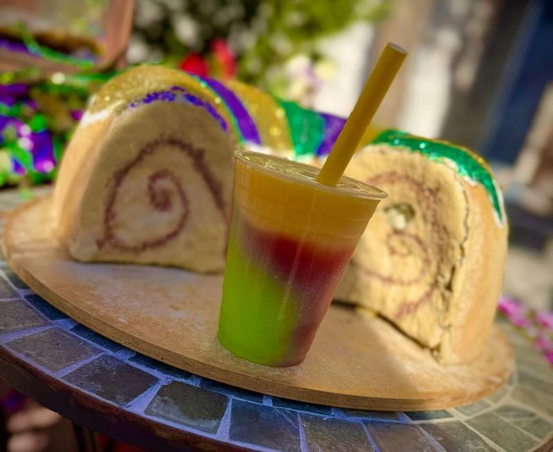 layered colorful frozen cocktail in front of a cake