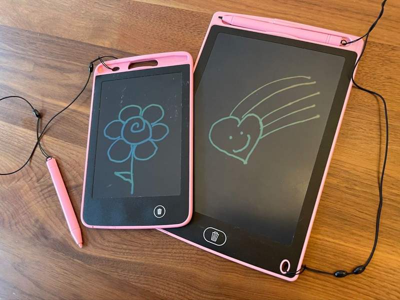 Two portable LCD drawing boards featuring drawings rest on a table.