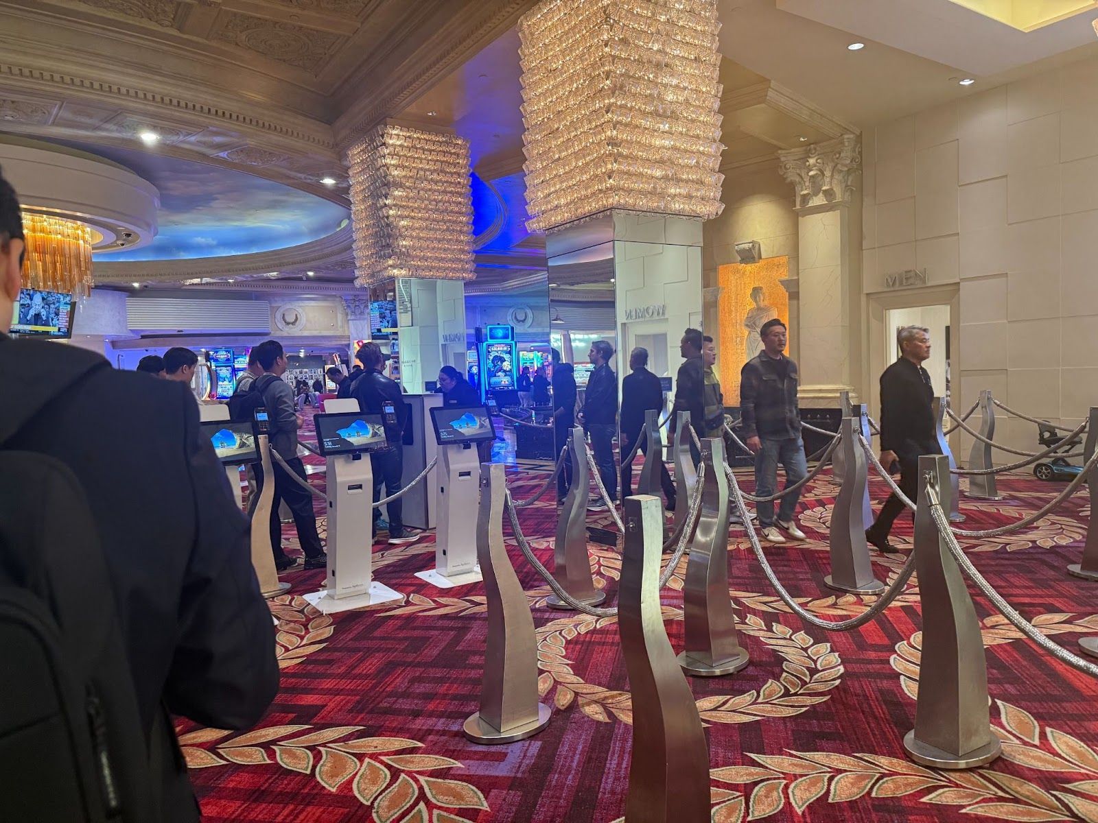 lines of people in a dark room with red carpet