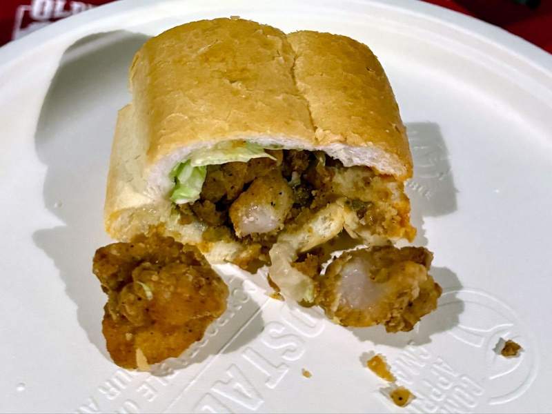 A shrimp Po’boy sandwich on a white plate.