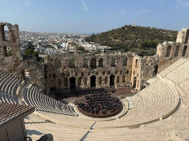 Looking down across the rows of seat at the stage area of an ancient Greek amphitheater.