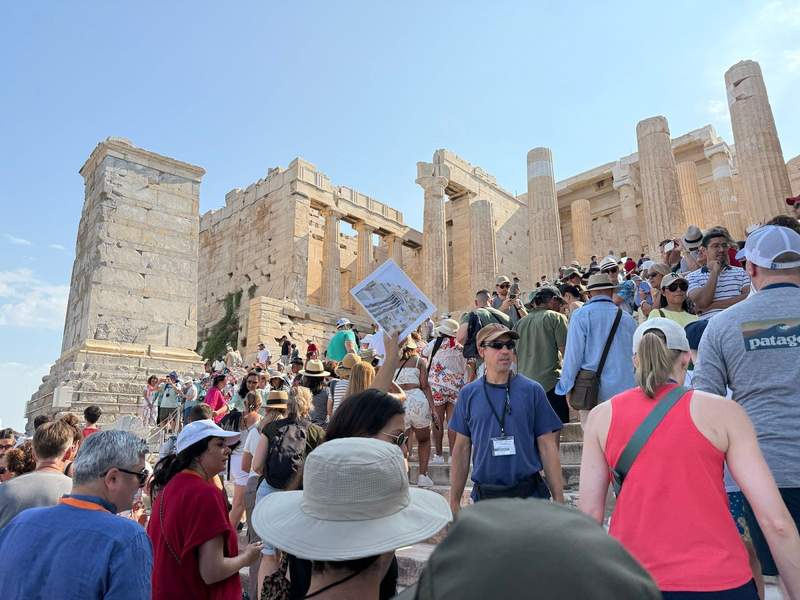Acropolis steps filled with tourists waiting and milling about.