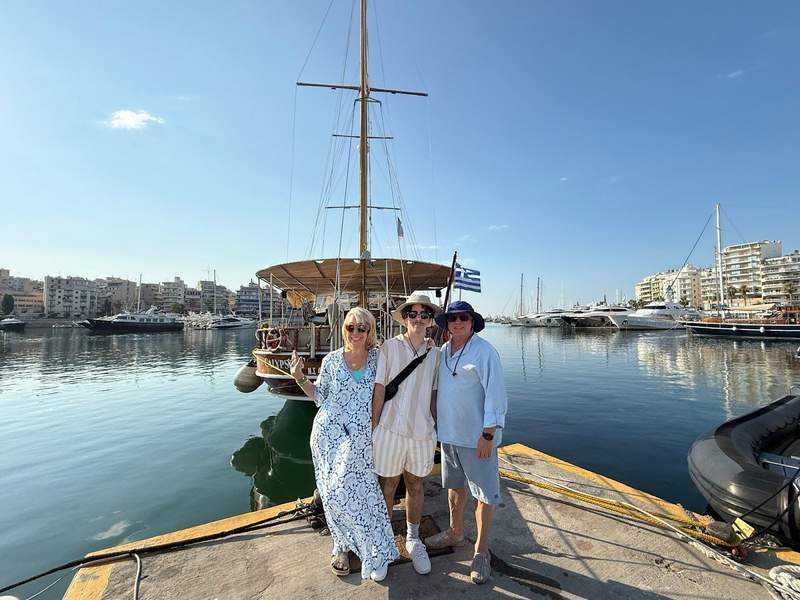 Family posing on wharf in front of a boat.