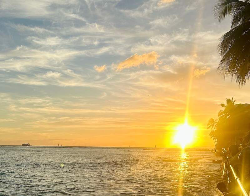 the sun setting over the ocean in Waikiki Beach Hawaii.