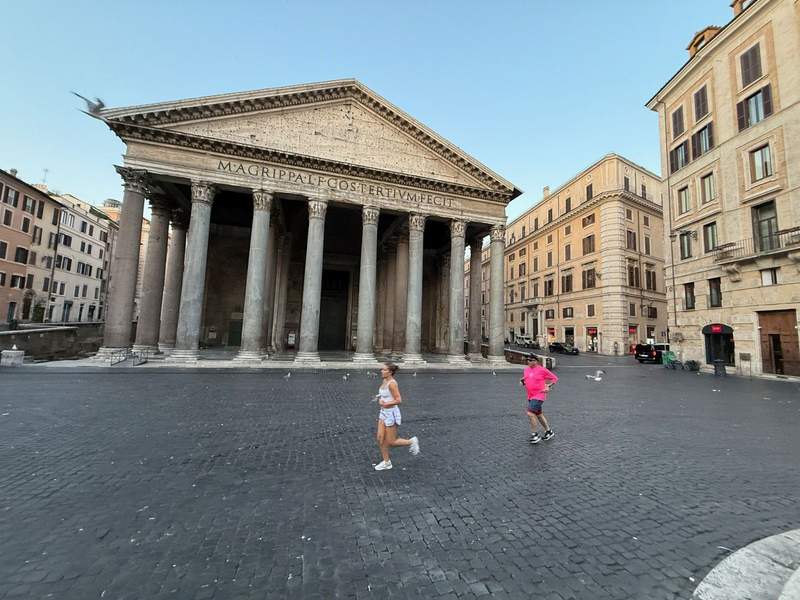Joggers run by the empty Pantheon in Rome.