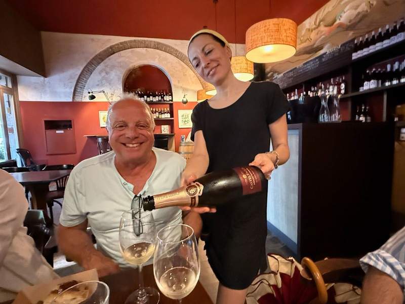 Waitress pouring wine into a man’s glass.