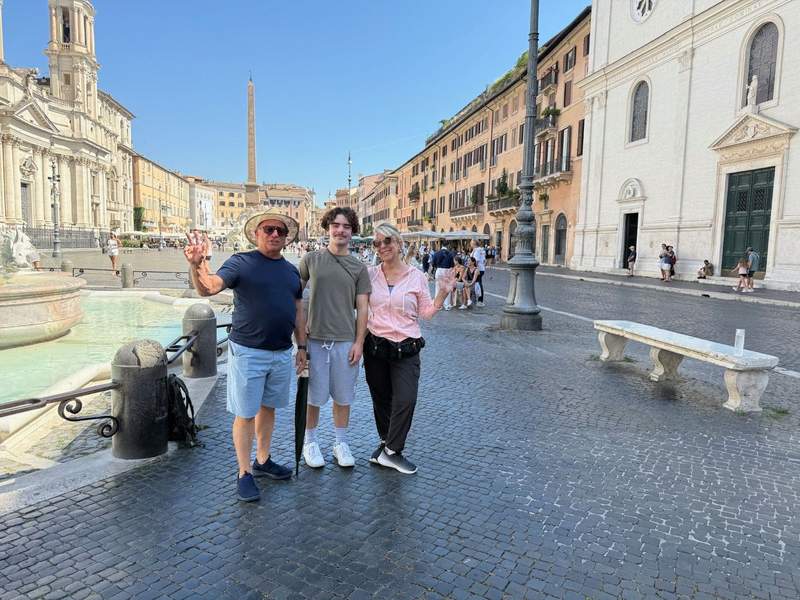Family posing by a fountain in the Piazza Navona in Rome.
