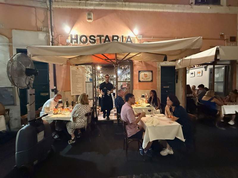 People sitting outside a little Italian cafe.