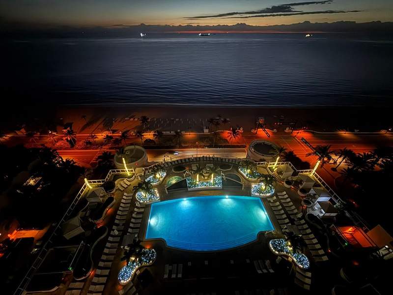 Balcony view of the night sky and lit pool of the Hilton Beach House in Fort Lauderdale