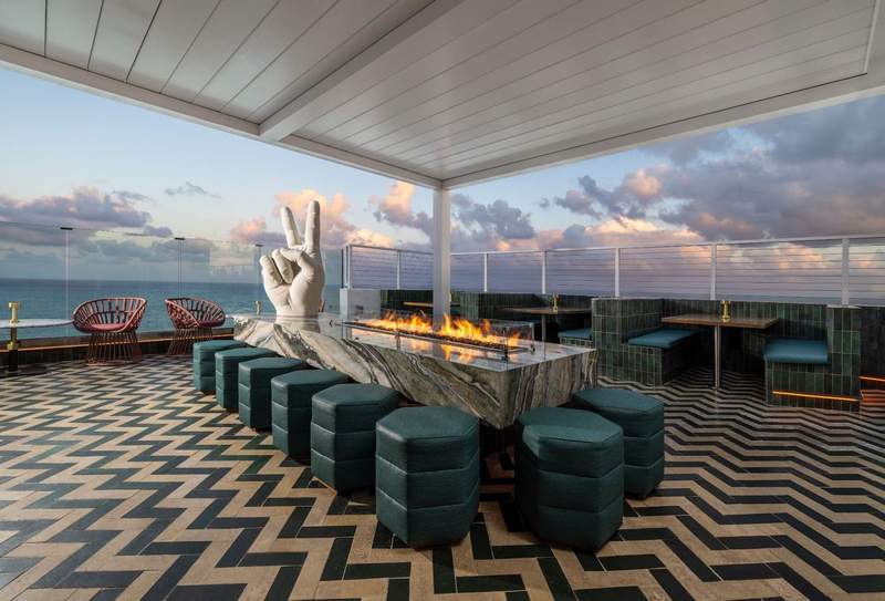  A rooftop lounge with an art sculpture of the peace finger overlooks the ocean at Hilton Beach House in Fort Lauderdale Beach, FL