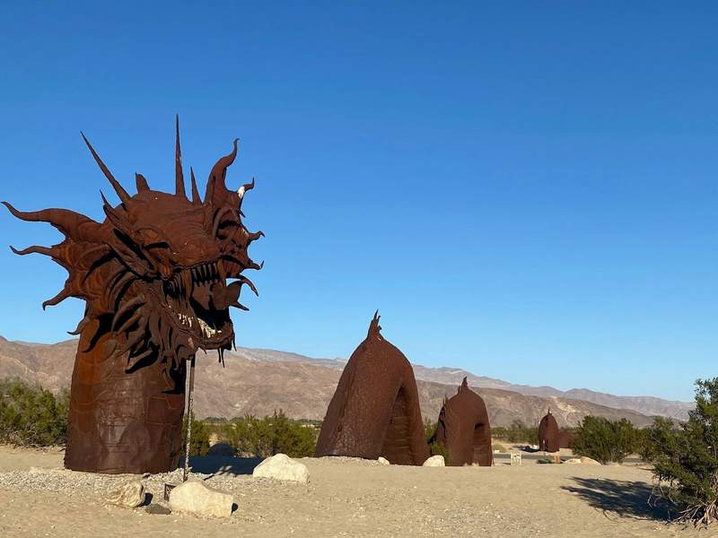 Metal sculpture in a dessert with a bright blue sky