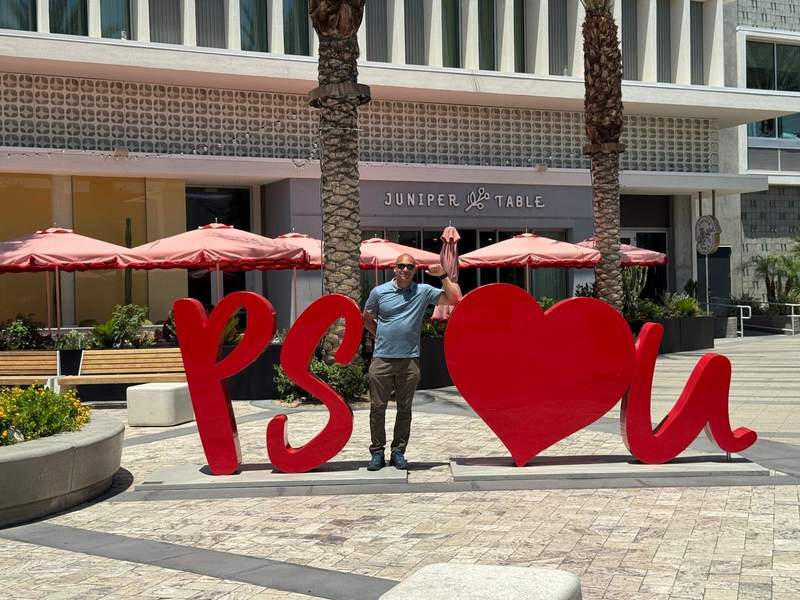 Man standing between large red letters and a heart in Palm Springs