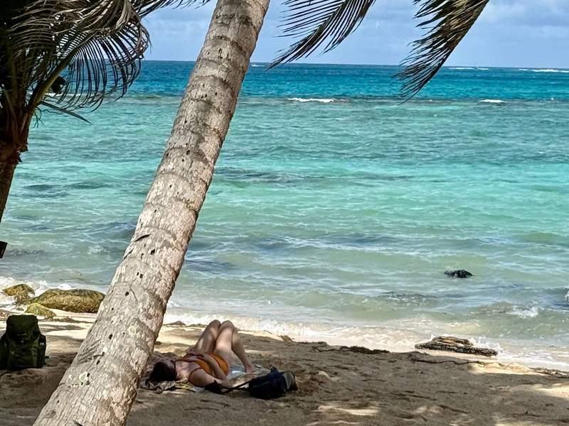 Lazing on the beach next to aquamarine waters.
