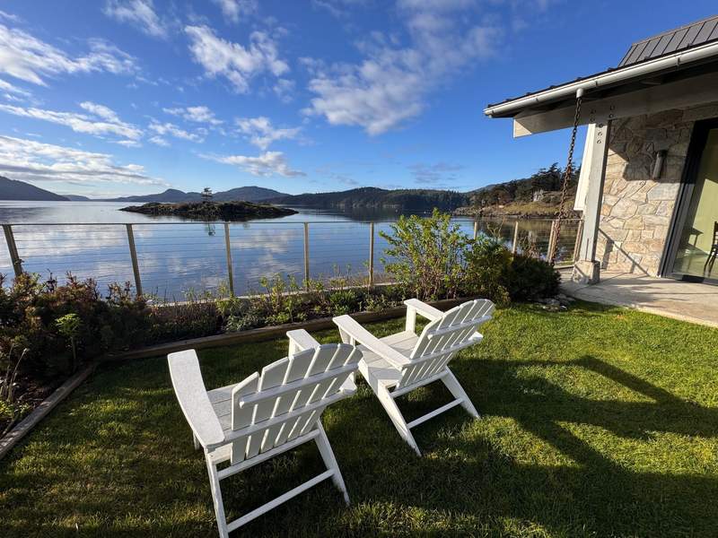 Two Adirondack chairs on a grassy courtyard overlooking the scenic Fishing Bay