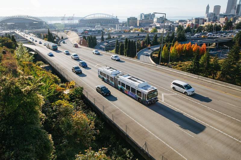Sound Transit bus on Interstate 5 with Seattle skyline in the background.