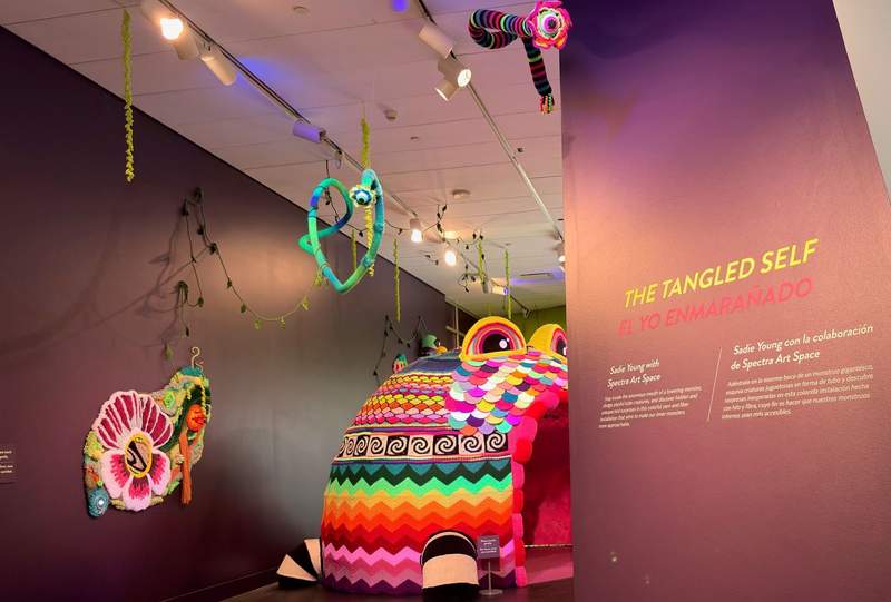Very colorful strips, wall art and a large igloo shaped object hanging from the ceiling at the Denver Art Museum