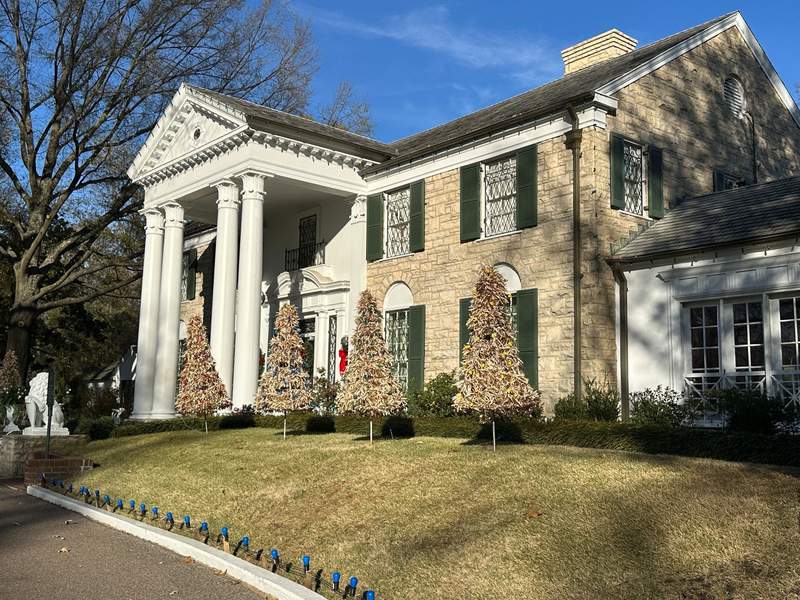 A house with a stone exterior and white pillars in front.