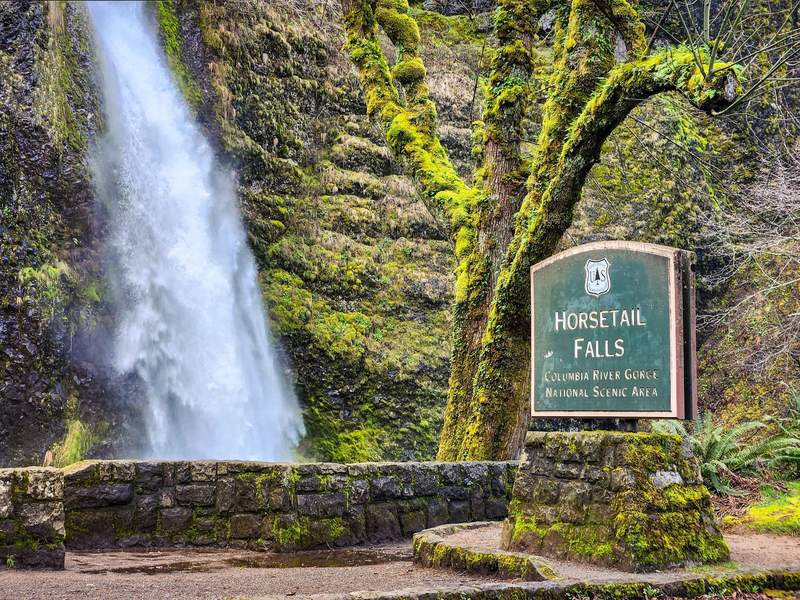 Waterfall with stone wall and sign