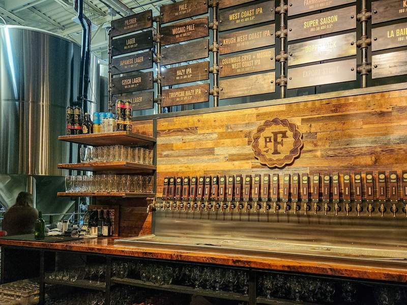 A kitchen counter backed by a row of beer taps
