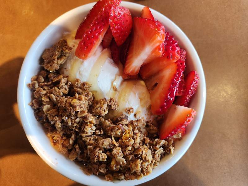 Bowl of yogurt with granola and strawberries