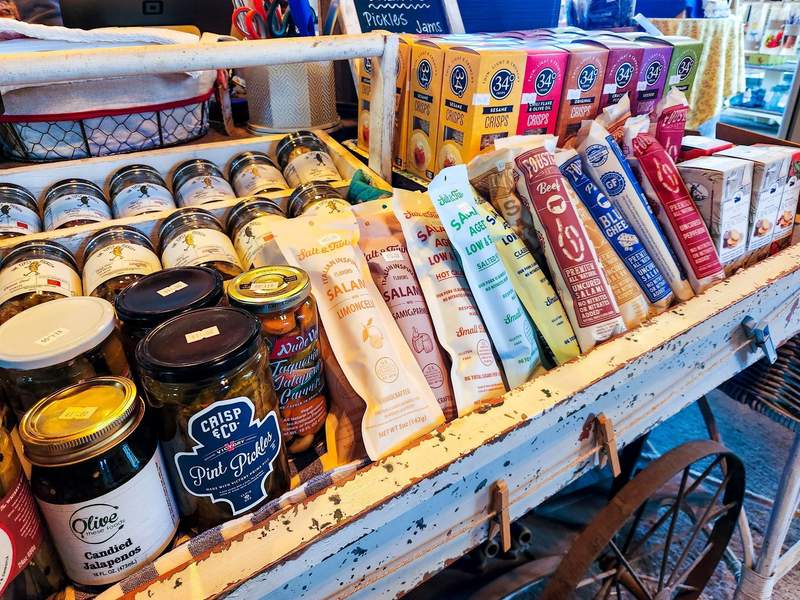 Jars of gourmet foods and wrapped salamis on display