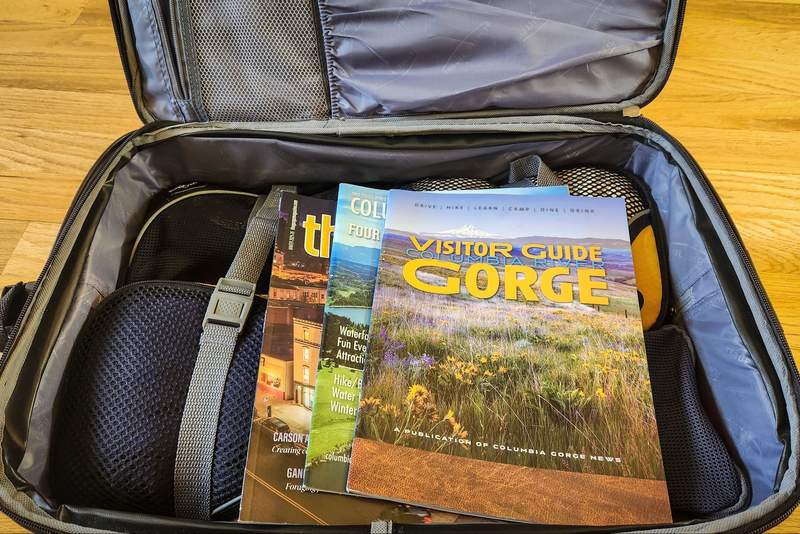 Packed suitcase with visitor guides on top