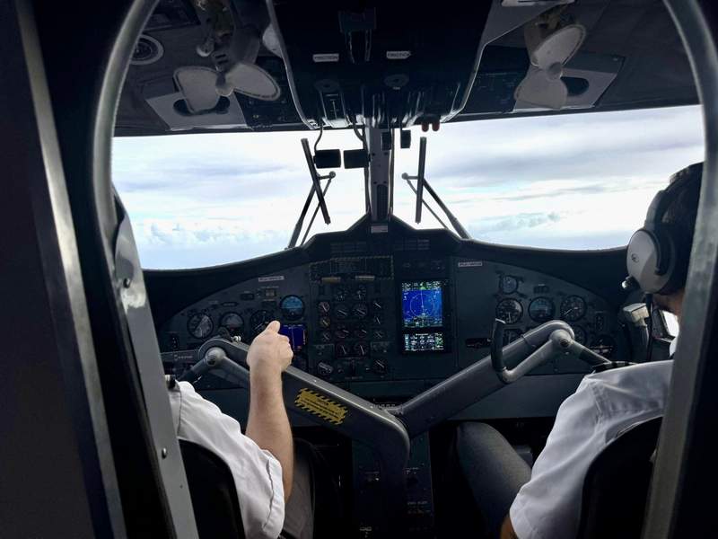 View of an open cockpit with pilots visible up close during flight.
