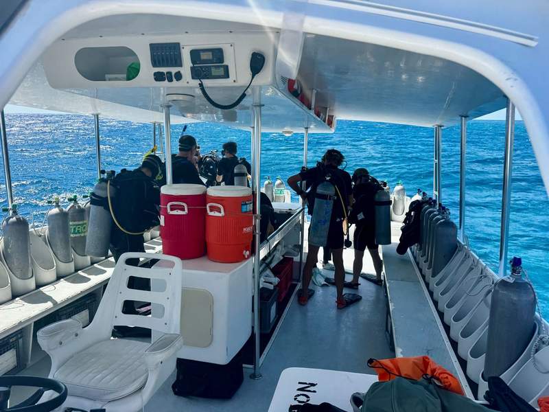 The Sea Saba dive boat arrives at a dive site as divers prepare to enter the water.