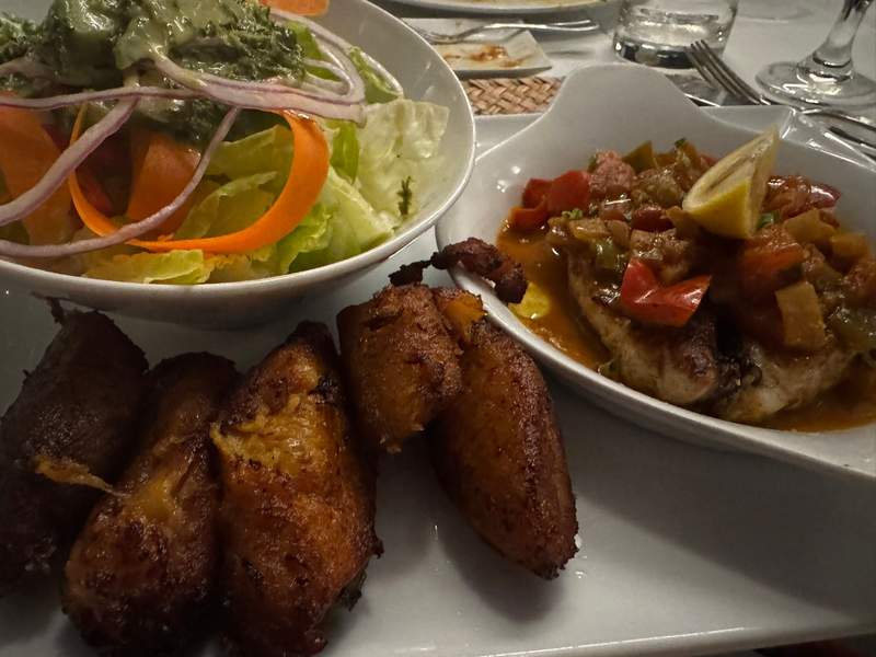 Close-up of grilled fish with salad and sweet plantains at Tropics Cafe.