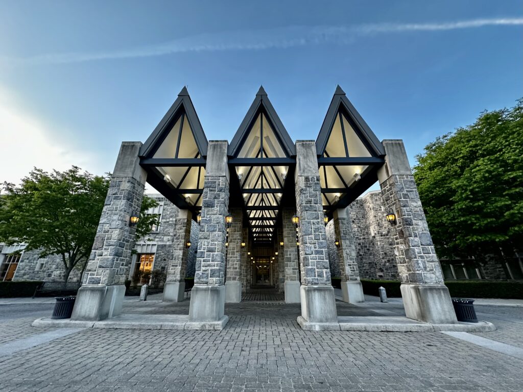 Three illuminated glass peaks atop the stone-columned entrance to the Inn at Virginia Tech in Blacksburg, Virginia.
