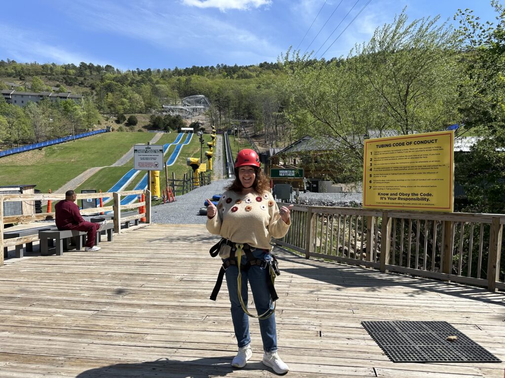 Woman wearing a red helmet and zip line harness at Massanutten resort.