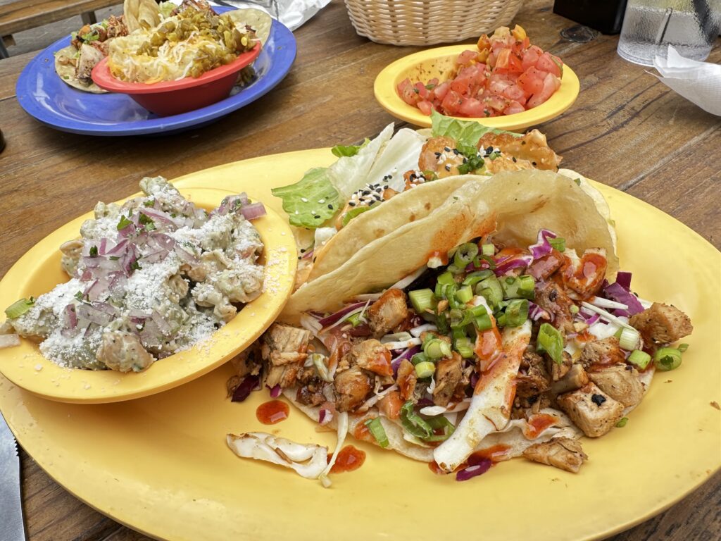 Tacos and avocado pasta salad on yellow plate at Cabo Fish Taco in Blacksburg, VA.