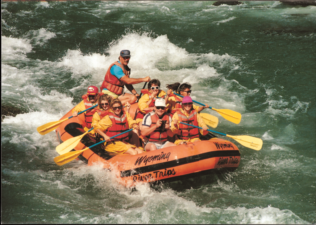 Orange raft with passengers on the Shoshone River in Cody Wyoming