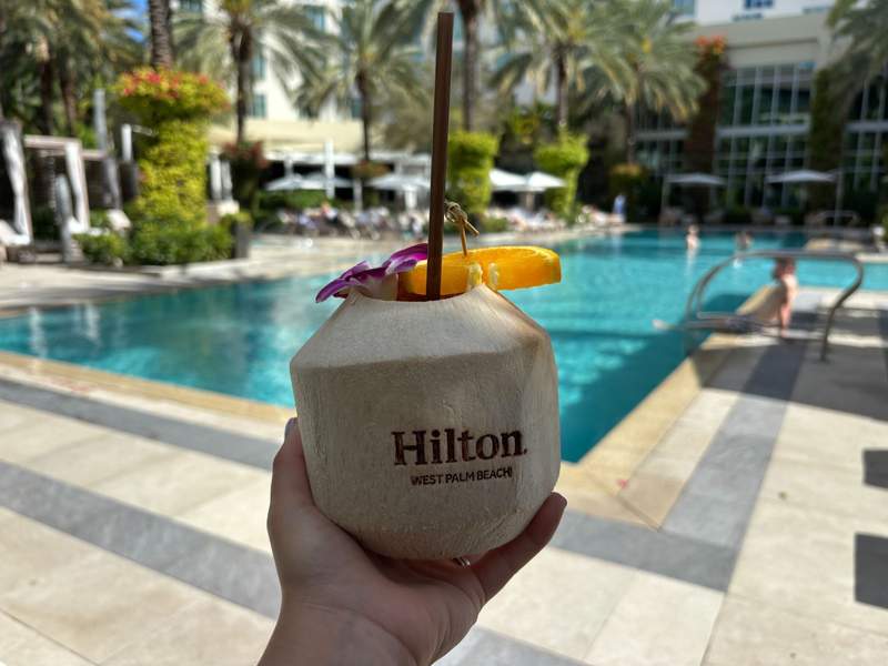 Branded tropical coconut drink at Hilton West Palm Beach with pool in background