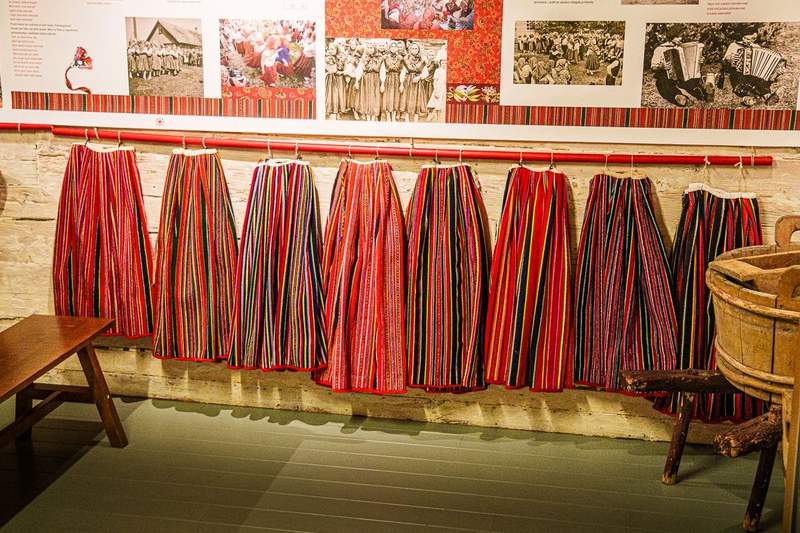 A row of colorful striped skirts with red and black being the dominant colors.