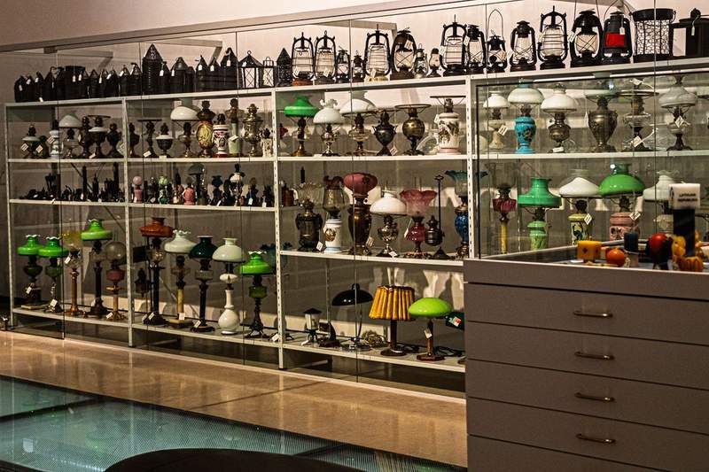 Shelves lined with many different styles of oil lamps