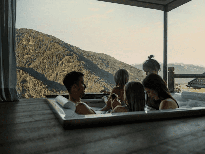 A couple with young children in an in-room hot tub at Sonnwies Resort