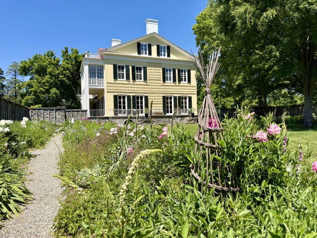 Yellow home with garden obelisk in foreground