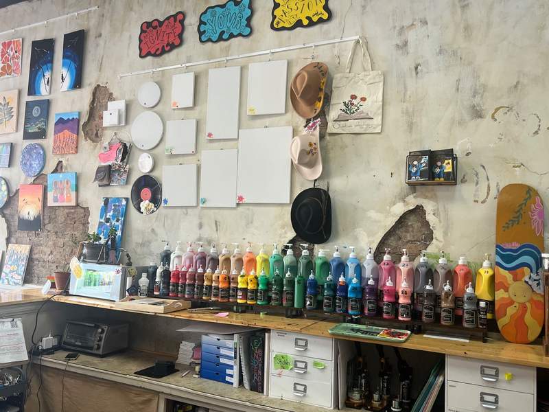 Wall of paint and projects hang on display at ArtLink.