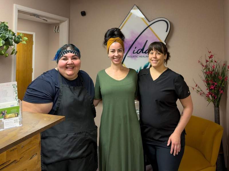 Three women standing together inside Vida Holistic in Yuma during a wellness visit.
