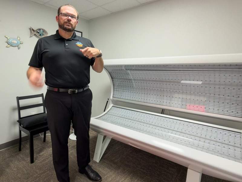 Owner Brian Nance, standing beside a wellness therapy bed inside a treatment room at Elemental Life Spa.