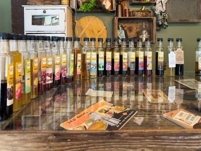 Bottles of infused olive oil lined up for tasting inside Desert Olive Farms in Yuma.
